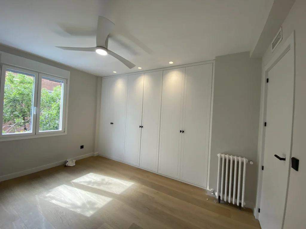 Reforma dormitorio Madrid armarios blancos a medida suelo madera