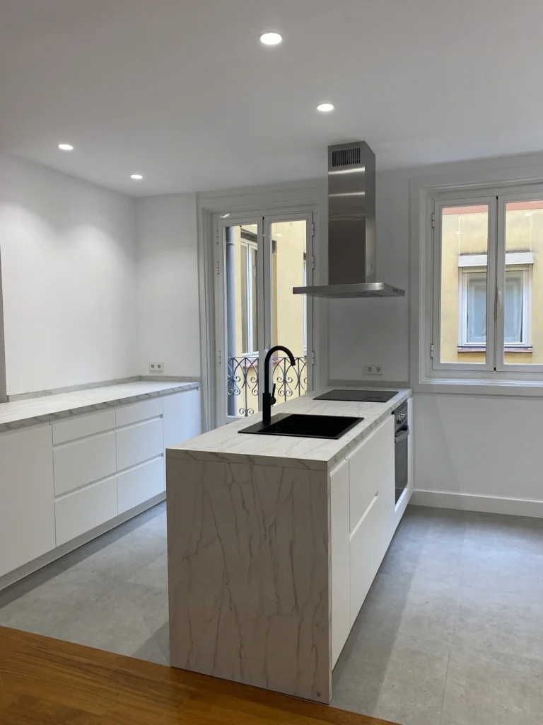 Reforma integral cocina blanca con isla de cuarzo en Calle Justicia, Madrid, diseño minimalista Mokara Estudio